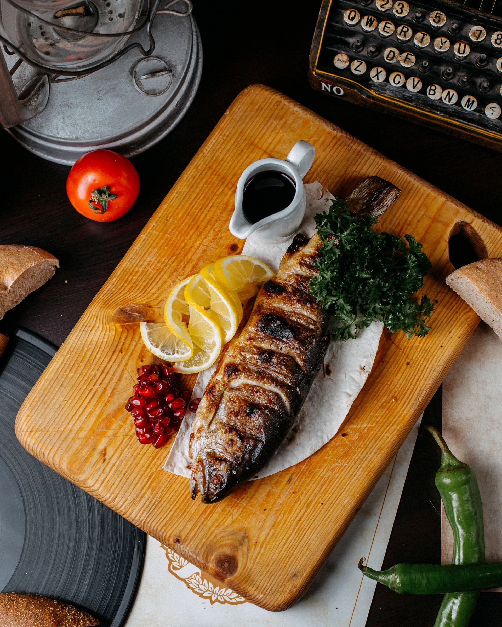 top-view-grilled-trout-with-lemon-pomegranate-seeds-wooden-cutting-board.jpg